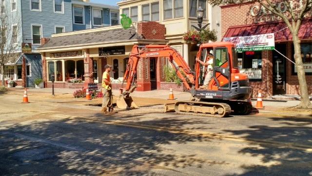 Town workers finishing repairs on a burst water main