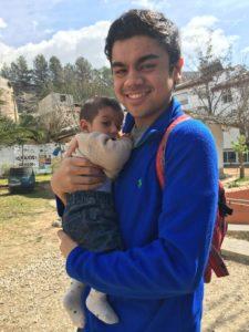 Noah Borromeo holding Rambo, the first day we met him. While Rambo looks slightly fearful in this picture, a few moments later Noah will manage to coax out a smile to match his own. Photo credit to Alex Horn.