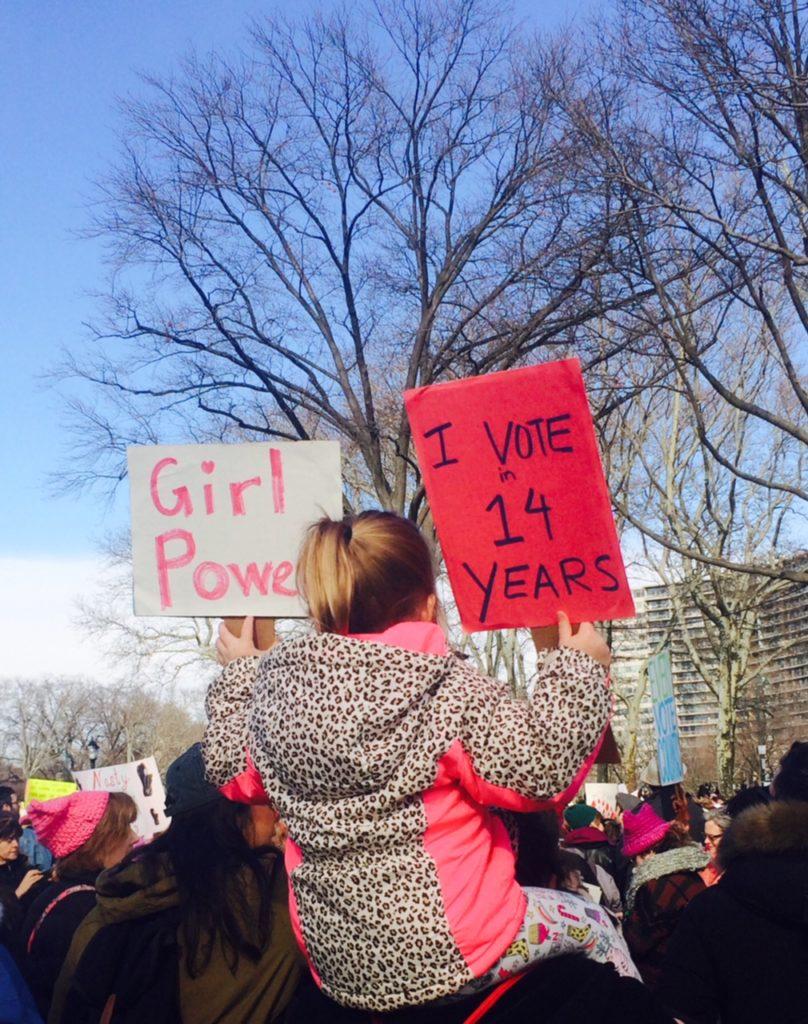 A young girl holds up her signs at the Philadelphia Women's March. 