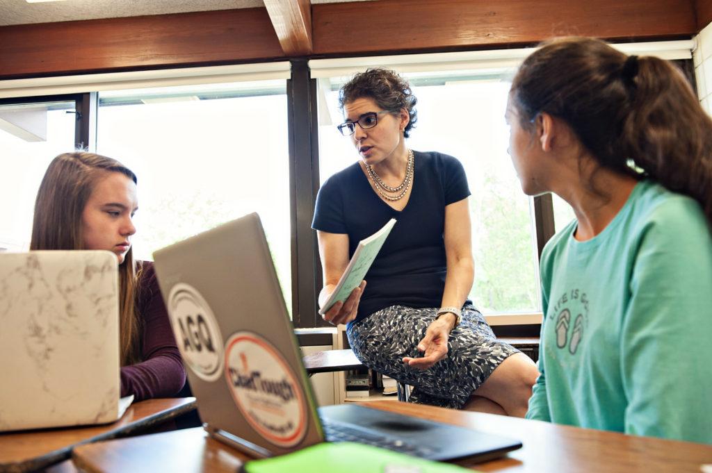 Ms. de la Torre works with students in the classroom. Photo courtesy Ms. de la Torre