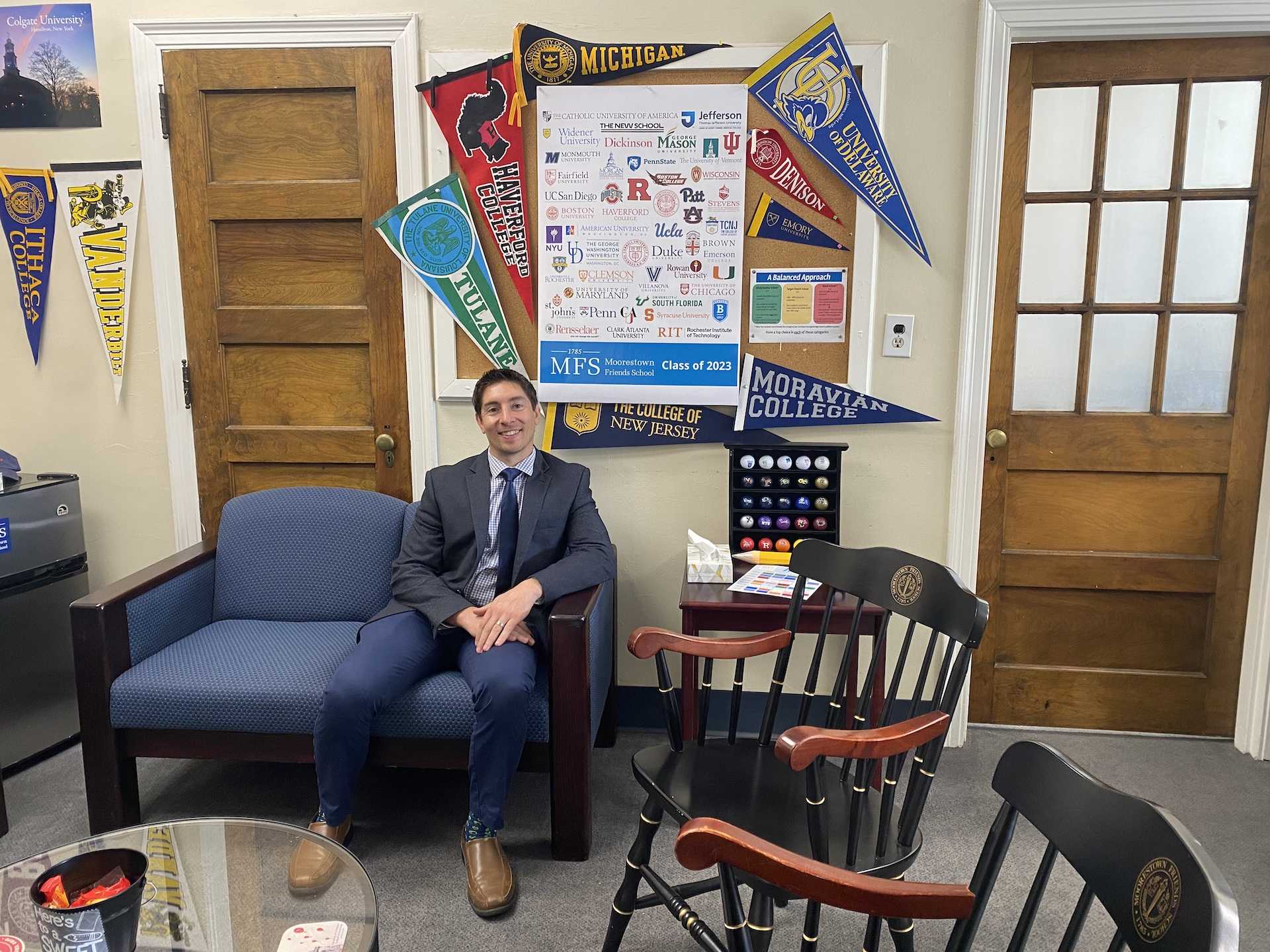 Chris LaTempa sits in his office surrounded by his array of college pennants. Picture Credits: Hannah Puc ’24