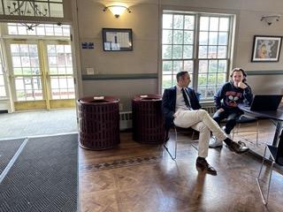 Upper School Director Noah Rachlin sits by the door on Tuesday, March 19, to ensure that students do not leave with reusable plates or utensils. Photo by Sophia Lalani '25.