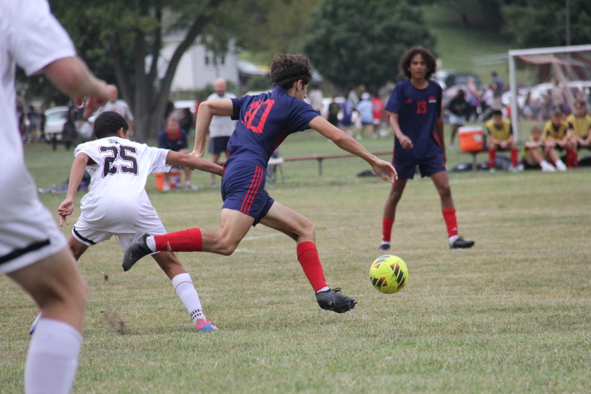 Preston Galanis ’25 about to strike the soccer ball on the field. Photo by Charlotte Nesevich '25.
