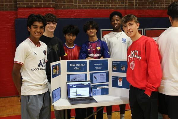 Investment Club officers Mason Levens ’25, Gabe Harvey ’25, and Vikram Verma ’25 stand by their booth in the 2024 club fair. Photo courtesy of Miles Wilkins ’25 and the Moorestown Friends Cupola Yearbook Staff. 
