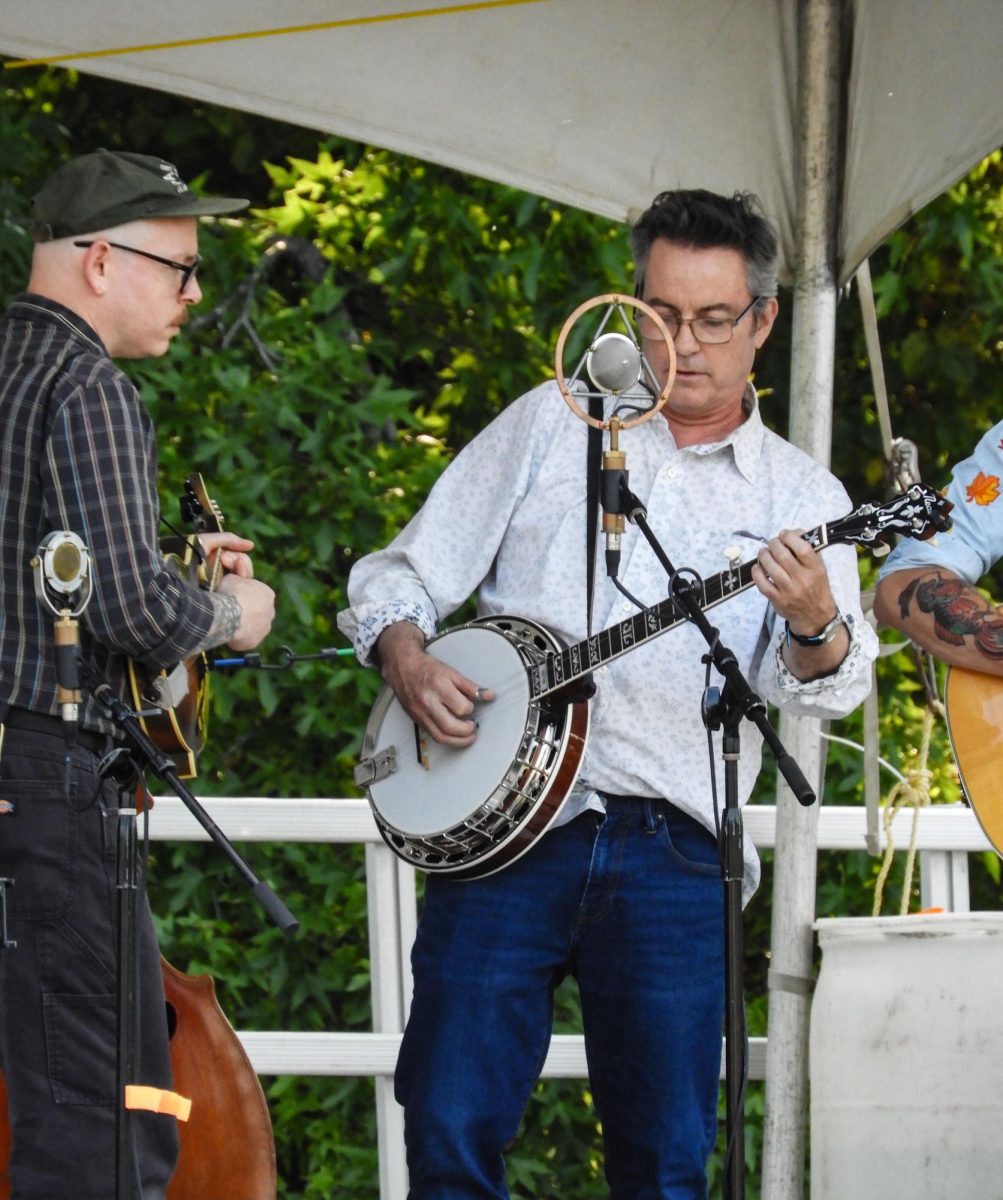Andy Davis plays banjo on stage with Midnight Flyer. Photo by Chloe Marshall '26.