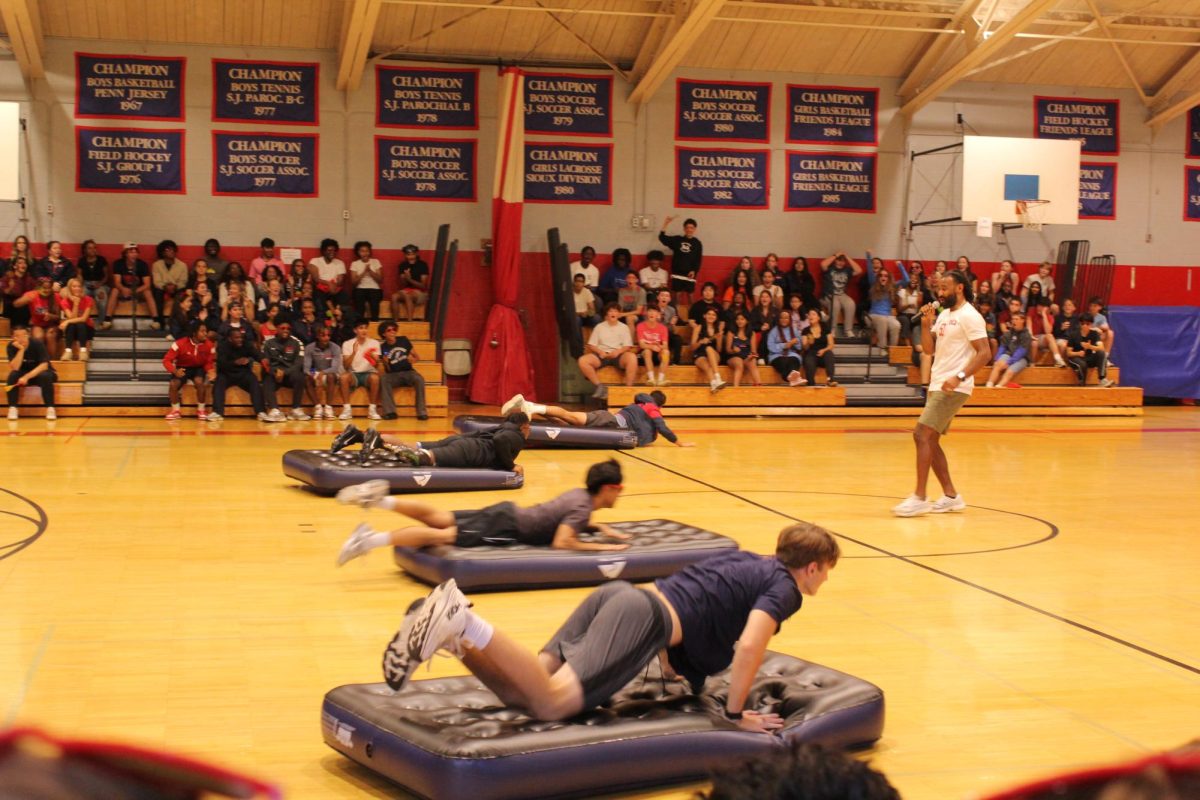 Isaiah Coleman leads students from each grade level in a game of mattress surfing. Photo by Erika Capella '27.