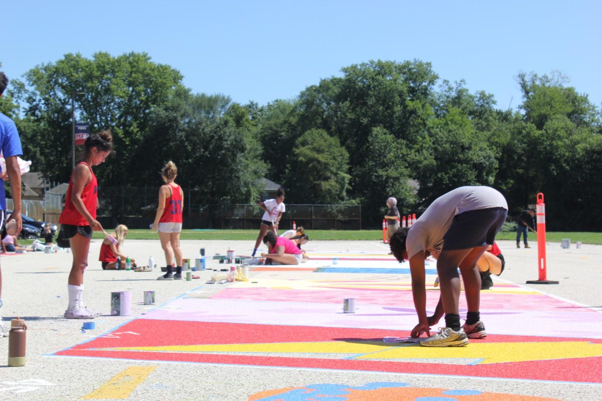 Seniors in the Class of 2026 work on painting their parking spots. Photo by Emmie Huynh '27.
